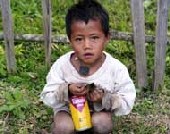 Boy holding an obsolete pesticides container in Laos
