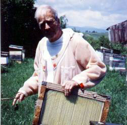 Figure a) Mr. Mraz with an electro-shock venom collector in his beeyard.