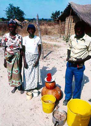 Beer brewer selling her product from traditional gourds.