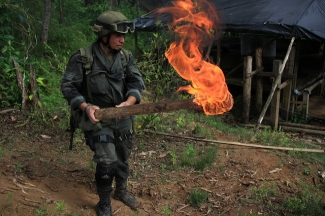 stand on guard after burning a coca laboratory near Tumaco, Colombia
