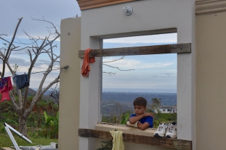 A child stands in what is left of his house in Utuado, Puerto Rico, which was almost completely destroyed by Hurricane Maria Oct. 12, 2017.