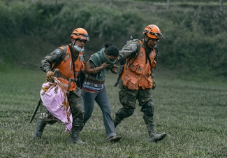 Conred rescue teams helping a victim in the area near the volcano