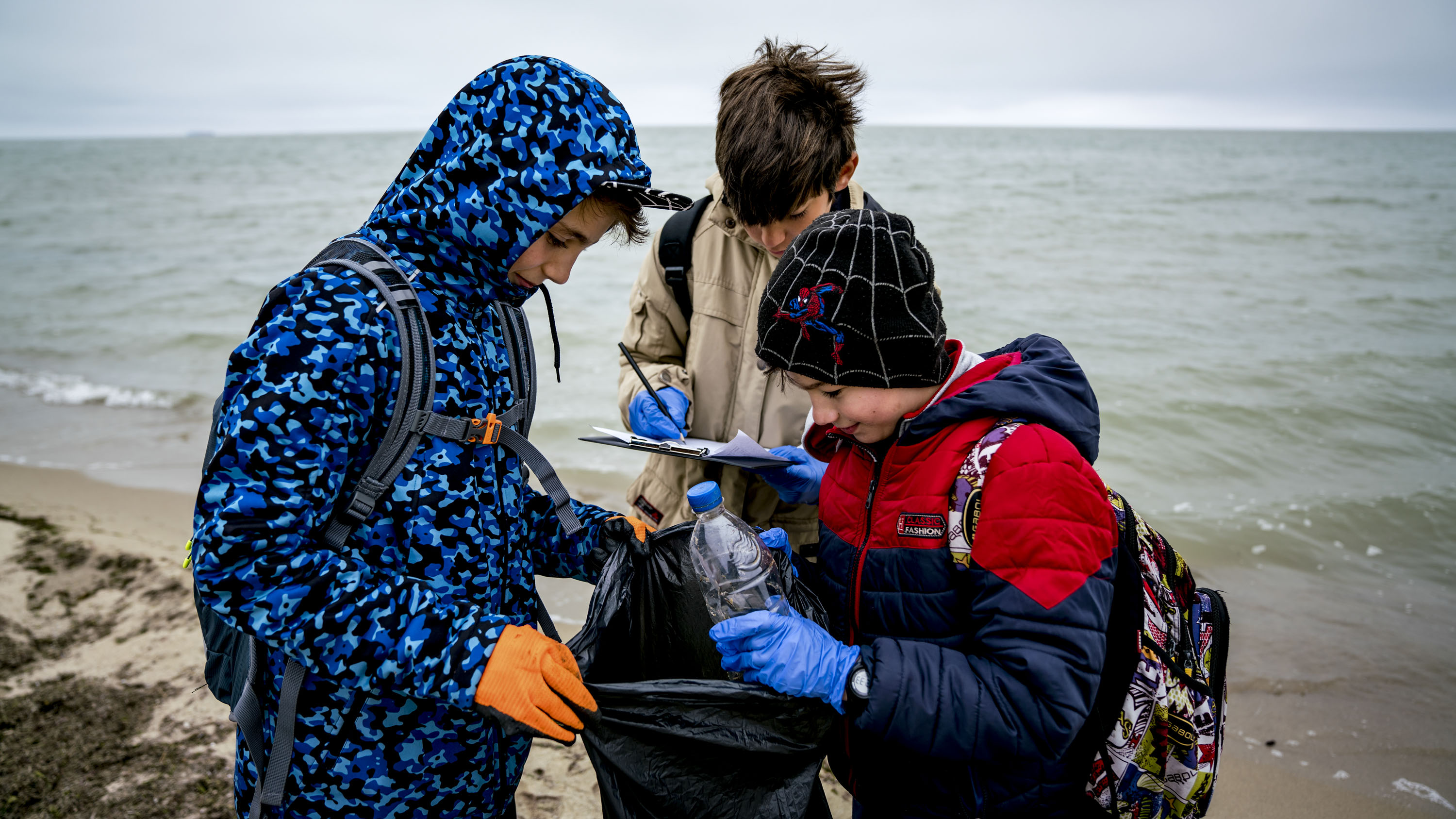 Varna, Bulgaria - Children collect and categorize litter on the beach of Kamchia.