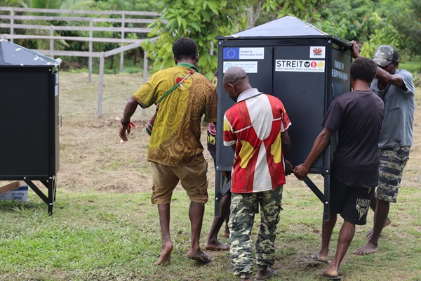 Vanilla farmers from the Sepik region of Papua New Guinea carry a solar dryer provided by the FAO, under the EU-STREIT PNG Programme. ©FAO-STREIT