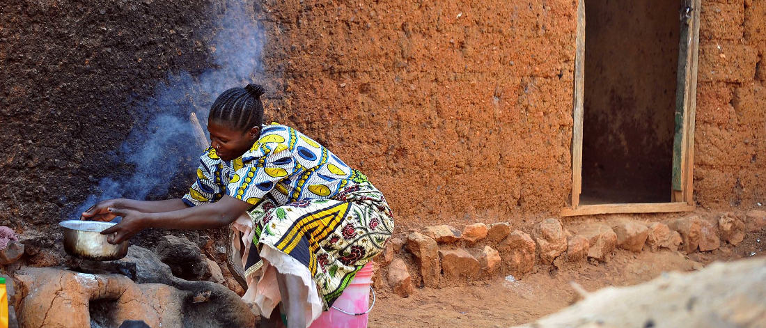 Africa, Kigoma, Tanzania - A woman cooking outside her home. ©FAO/Simon Maina